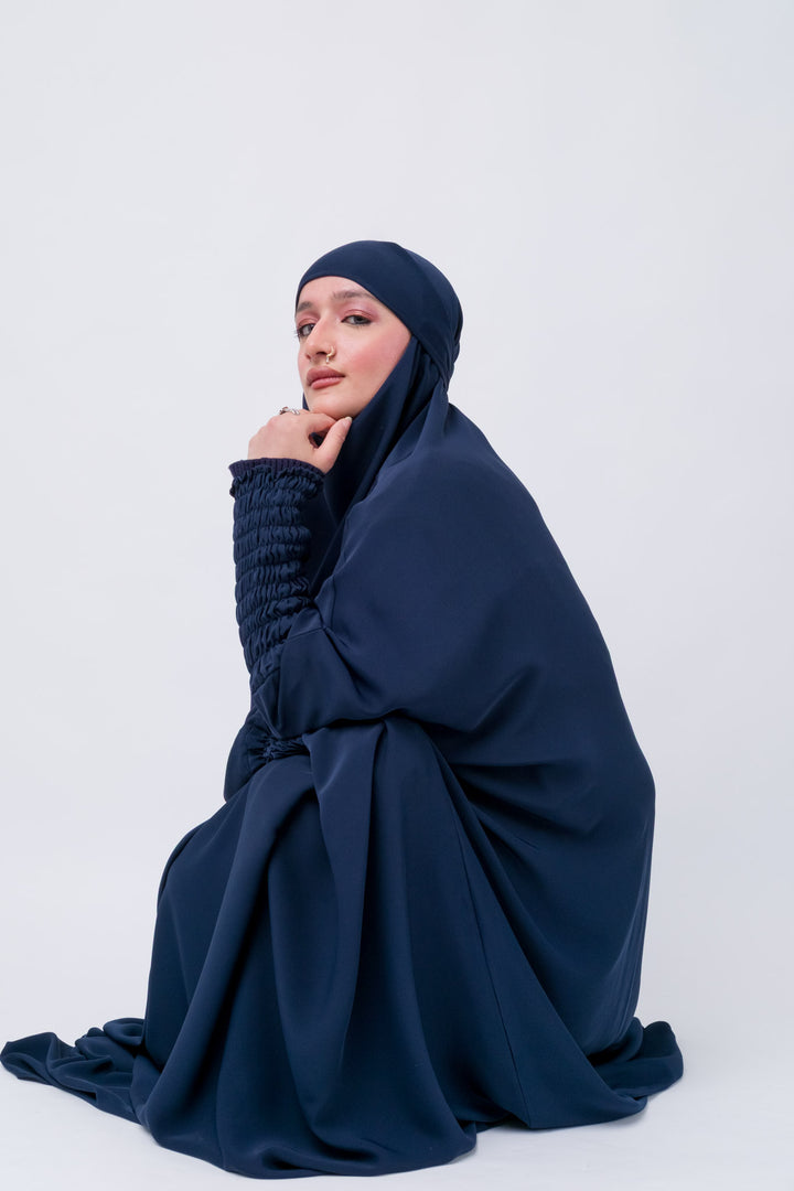 Modest Islamic khimar in deep navy, one-piece abaya style with smocked sleeves for comfort.