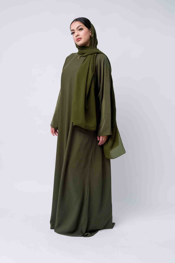 Flowy olive abaya with high neckline and hijab, ideal for modest occasion wear. 