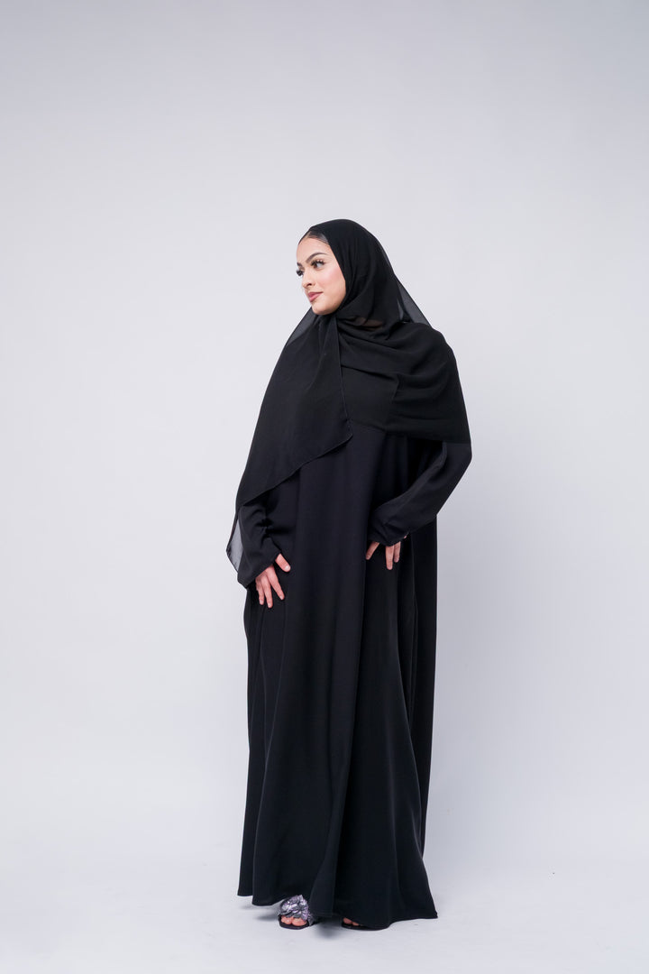 Modern black abaya with soft flowy fabric and hijab, chic Islamic fashion choice for any season.