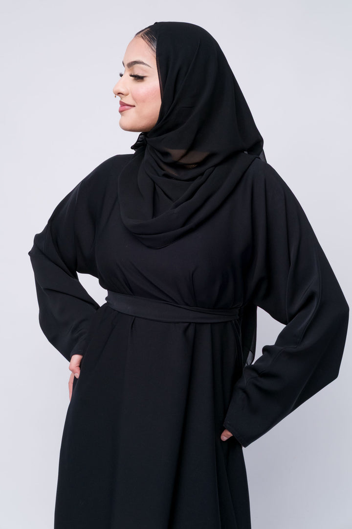 Full-length black abaya with belt and hijab, perfect choice for Muslimah dressing with elegance.