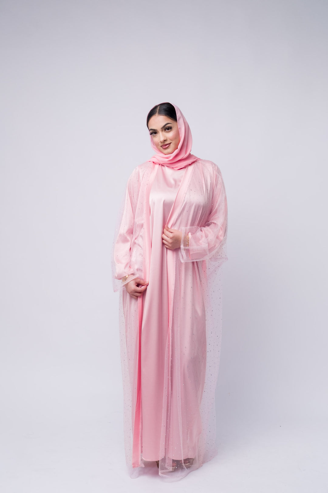 Elegant pink satin abaya with crystal-studded overlay and matching hijab for modest formal wear