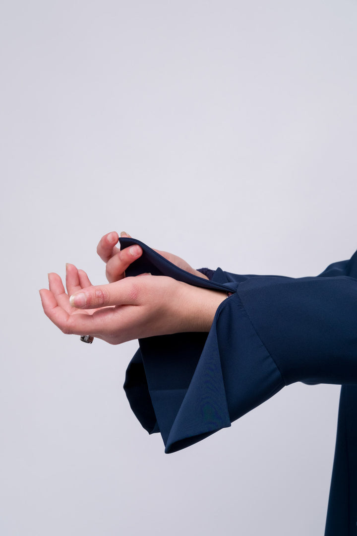 Flowing navy embroidered abaya with wide sleeves, modest and stylish Islamic wear. 