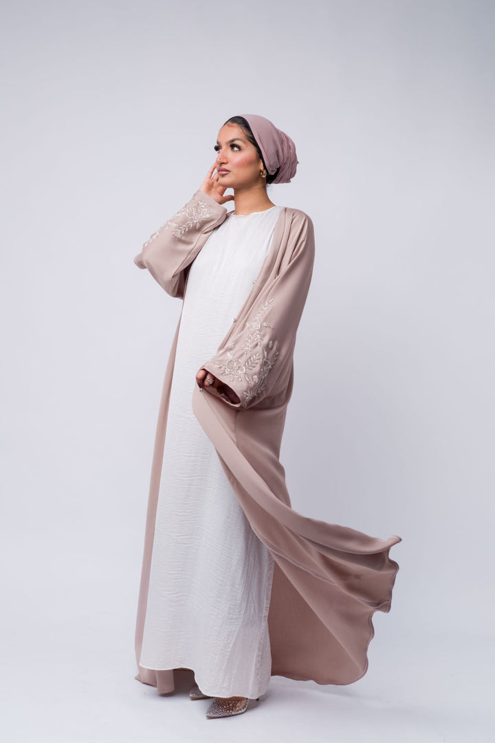 Open nude pink abaya with shimmering floral embroidery, modest wear for parties and events.