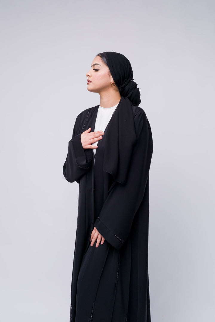 Stylish open abaya in black with delicate bead detailing, great for modern modest fashion.
