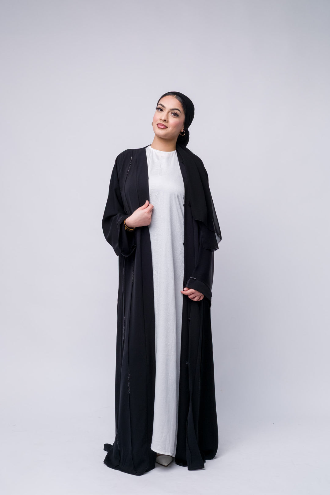 Front-open black abaya with sequin accents, a chic modest wear staple for day-to-night looks