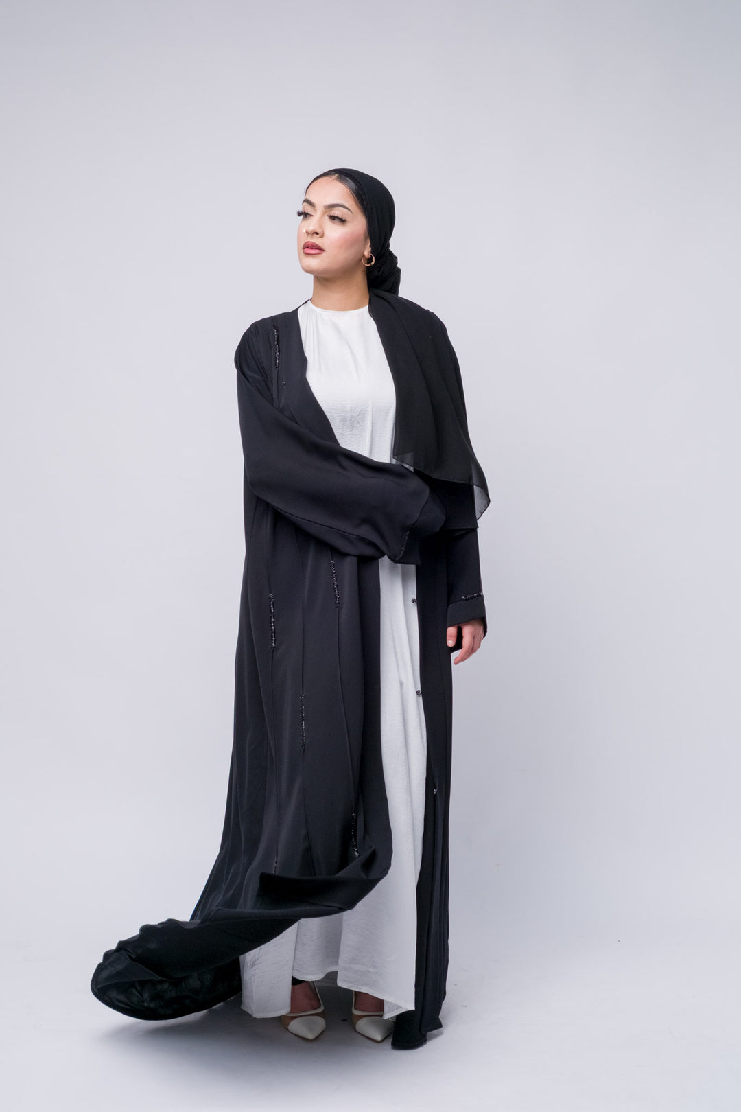 Black modest abaya with front button closure and shimmer accents, ideal for everyday elegance.