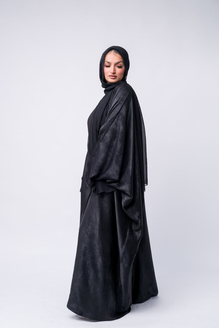 Black abaya with pleated detailing and hijab for Muslim women, perfect for modest fashion lovers. 