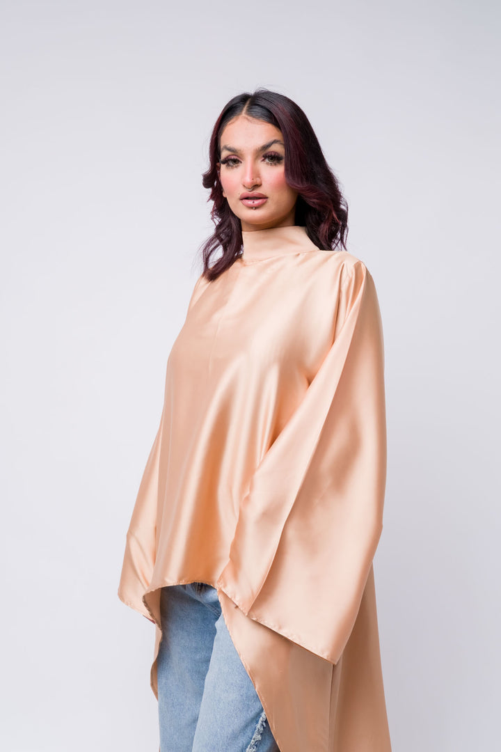 Modest satin top in peach paired with frayed wide-leg jeans – fashion-forward look