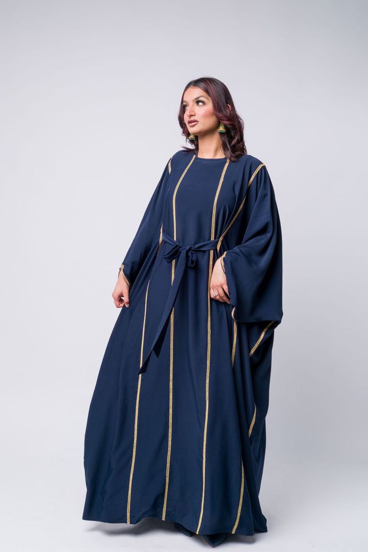 Stylish navy kaftan dress with gold vertical embellishments and belt, modern modest wear.