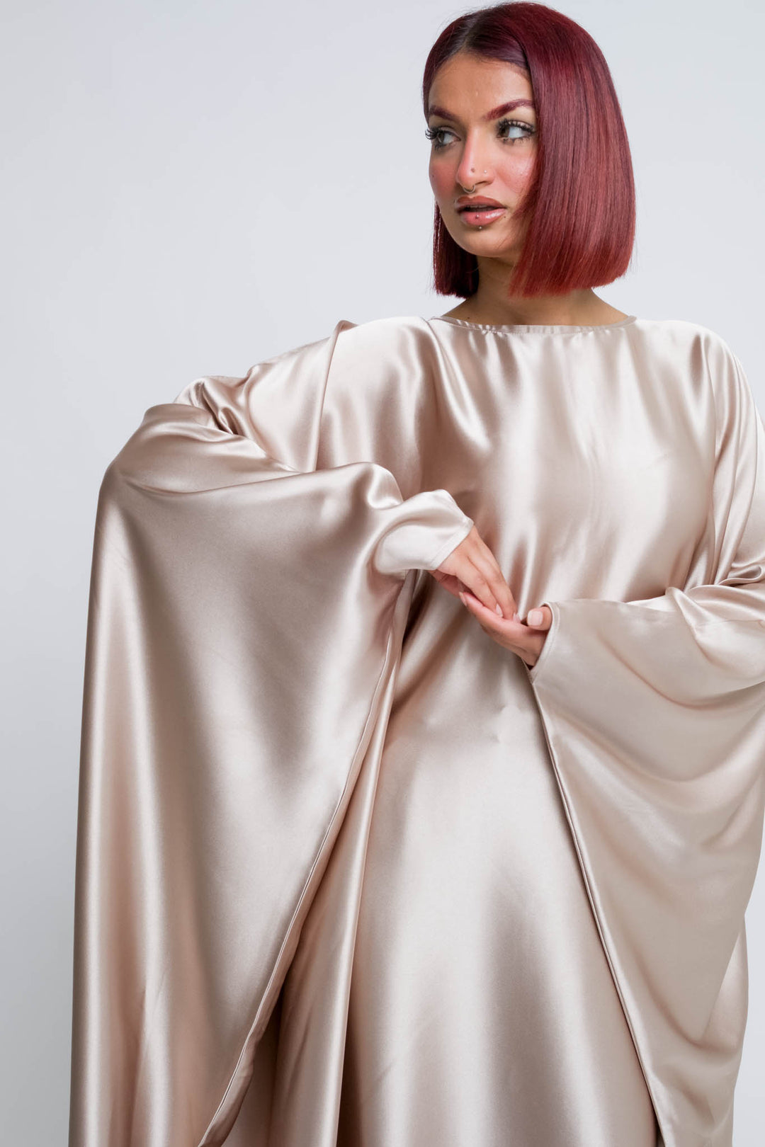 Woman wearing champagne blush satin abaya