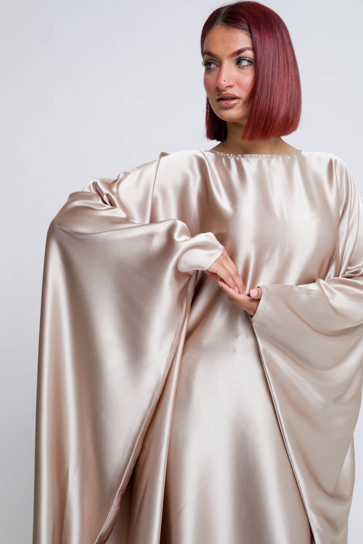 Woman wearing champagne blush satin abaya